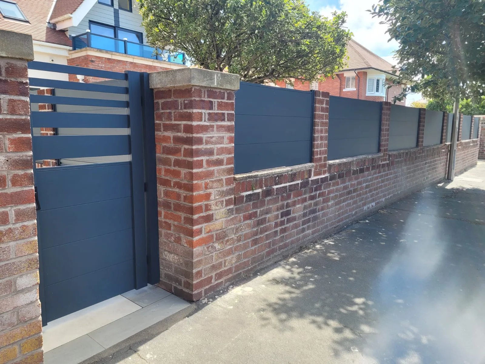 Aluminium fencing panels fitted along a brick front garden wall